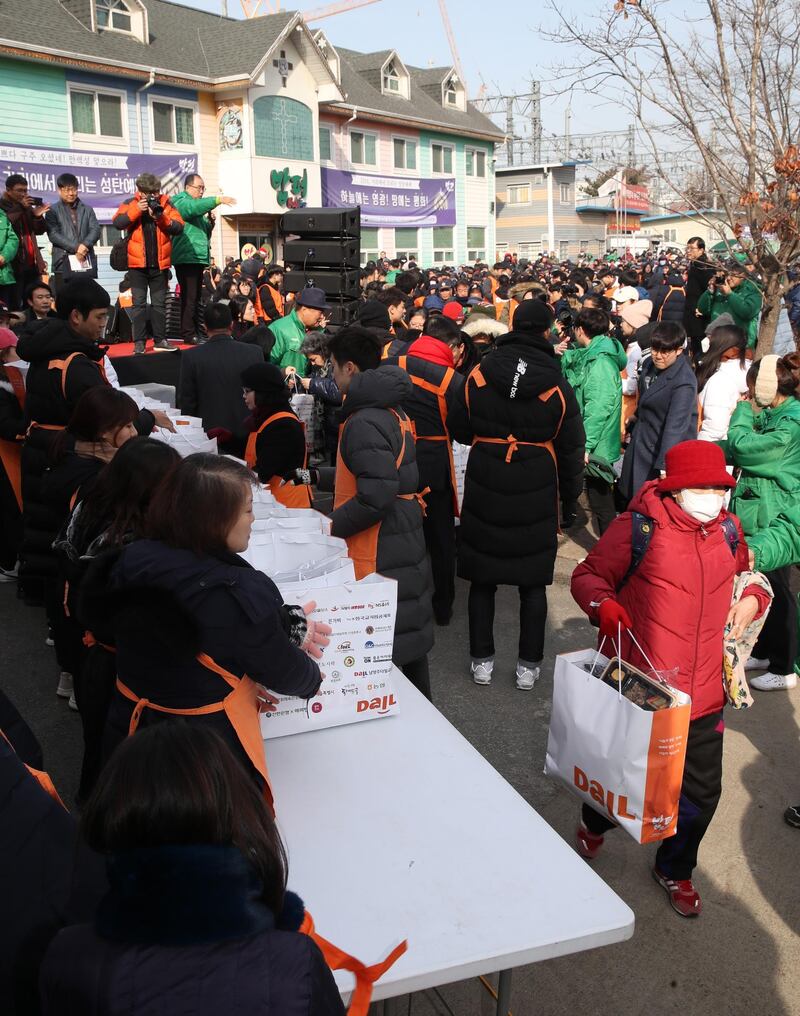 Workers and volunteers give out free lunch boxes and other warm goods to citizens in Dongdaemun market in western Seoul, South Korea.  EPA