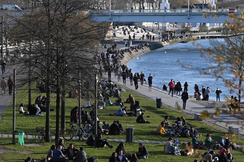 People walk along the bank of the Rhone river in Lyon. AFP