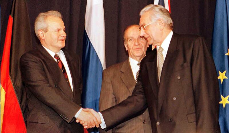 Alija Izetbegovic, president of the Republic of Bosnia-Herzegovina (C), looks on as Franjo Tudjman (R), president of the Republic of Croatia, and Slobodan Milosevic (L), president of the Republic of Serbia shake hands after initializing a peace accord 21 November between their countries. Negotiations hosted by the US known as the Proximity Peace Talks at Wright-Patterson AFB, near Dayton, Ohio, began 01 November 1995.    AFP PHOTO   John RUTHROFF (Photo by JOHN RUTHROFF / AFP)