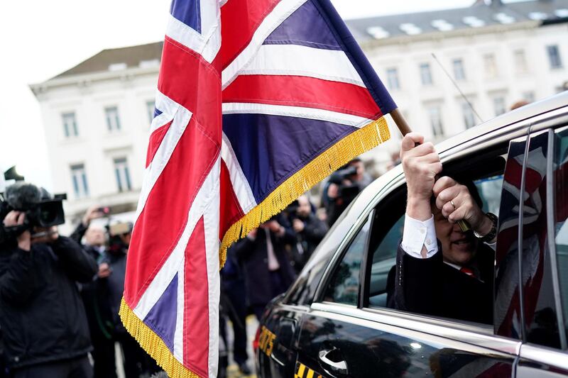Outgoing British MEP Jonathan Bullock sitting in a taxi holds the Union Jack flag as he and other British pro-Brexit MEPS leave Brussels. AFP