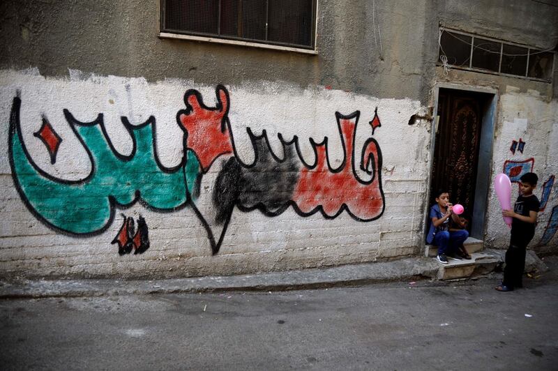 Palestinian boys play near graffiti reading: "Palestine" at Al Fariah refugee camp in the Israeli-occupied West Bank. REUTERS