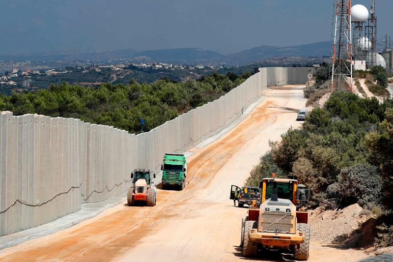 (FILES) A file photo taken on September 05, 2018 near the Rosh Hanikra border crossing in northern Israel, shows tractors along a new wall on the Israeli-Lebanese border.  The Israeli army said on December 4, 2018 it had detected Hezbollah tunnels infiltrating its territory from Lebanon and had launched an operation to cut them off. / AFP / JACK GUEZ
