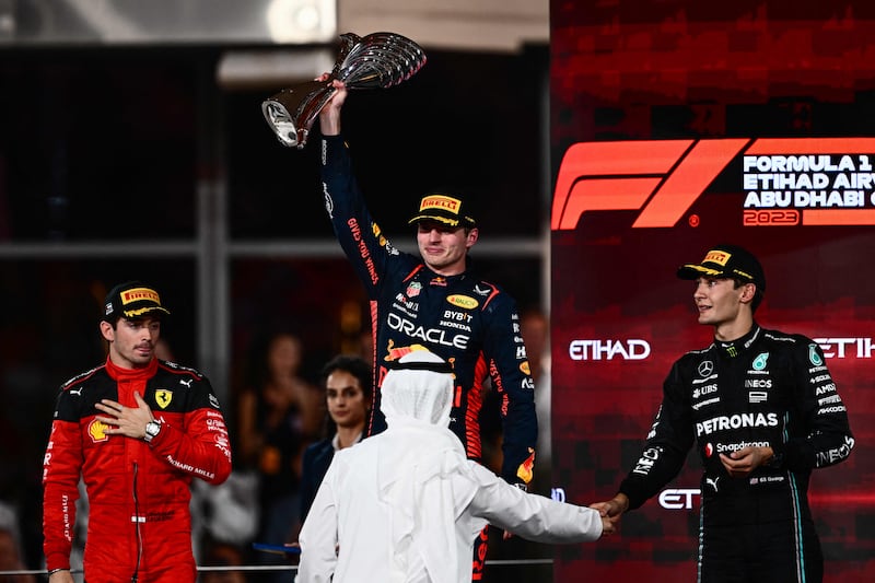 Red Bull's Dutch driver Max Verstappen celebrates on the podium with second place Charles Leclerc, left, of Ferrari and Mercedes' George Russell who was third. AFP