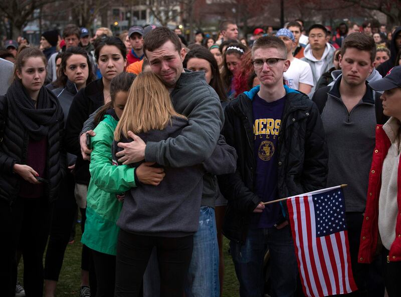 Scott Turner (C) is hugged by friends as he weeps at a vigil for bomb victims a day after two explosions hit the Boston Marathon, in Boston, Massachusetts April 16, 2013. The twin blasts on Monday killed three people including an 8-year-old boy and injured 176 others, some of whom were maimed by bombs packed with ball bearings and nails.  REUTERS/Adrees Latif  (UNITED STATES - Tags: CRIME LAW CIVIL UNREST TPX IMAGES OF THE DAY) *** Local Caption ***  AAL113_USA-EXPLOSIO_0416_11.JPG