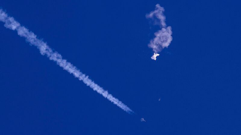 The remnants of the balloon drift over the Atlantic Ocean, just off the coast of South Carolina, with a fighter jet below it, on February 4. AP