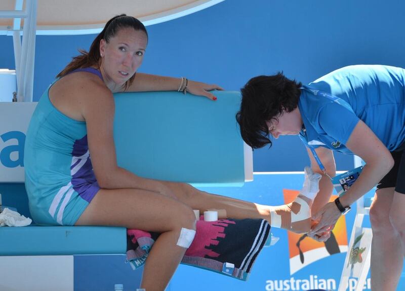 Jelena Jankovic of Serbia has her ankle attended to during a break against Misaki Doi of Japan. Saeed Khan / AFP
