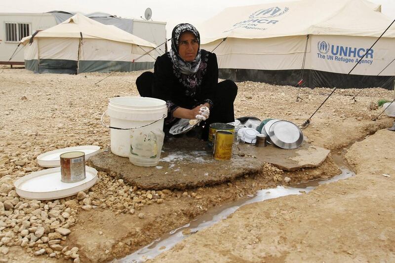 Um Mahmoud, a Syrian refugee, washes kitchen utensils at the Zaatari refugee camp in the Jordanian city of Mafraq, near the border with Syria. Muhammad Hamed / Reuters / March 8, 2014