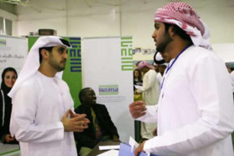 Fares al Mazroui, right, speaks to Abdullah al Hameli, of the Khalifa Fund, at the Al Gharbia Career Fair in Madinat Zayed on Nov 2 2008.