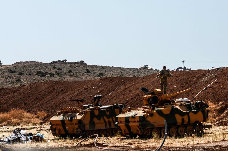 A Turkish soldier stands on an army armoured vehicle on October 8, 2017 at Syria-Turkey border at Reyhanli district in Hatay. 
Turkish forces exchanged fire Sunday with jihadists from Al-Qaeda's former Syrian affiliate on the border of Idlib province, a monitor and eyewitnesses said, a day after Ankara announced an imminent operation there. / AFP PHOTO / ILYAS AKENGIN