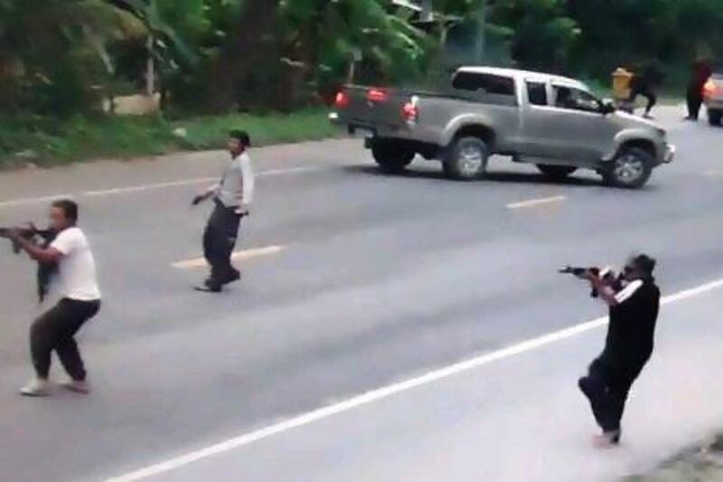 In this photograph taken from videotape footage, suspected separatist militants open fire with automatic weapons during an attack on Thai soldiers in Pattani on July 28. Four soldiers were killed and two others wounded.