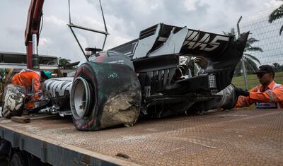 epa06233867 The car of French Formula One driver Romain Grosjean of Haas F1 Team is lifted to a tow truck after an accident during the second practice session ahead of the Malaysian Formula One Grand Prix at the Sepang International Circuit, near Kuala Lumpur, Malaysia, 29 September 2017. The 2017 Formula One Grand Prix of Malaysia will be held on 01 October.  EPA/AHMAD YUSNI