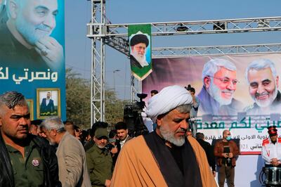 Supporters of the Popular Mobilization Forces hold a poster of Supreme Leader Ayatollah Ali Khamenei, center, and Abu Mahdi al-Muhandis, deputy commander of the Popular Mobilization Forces and General Qassem Soleimani, head of Iran's Quds force during a rally to commemorate the anniversary of the killing of Soleimanil and al-Muhandis in a U.S. drone strike in Basra, Iraq, Friday, Jan. 8, 2021. (AP Photo/Nabil al-Jurani)
