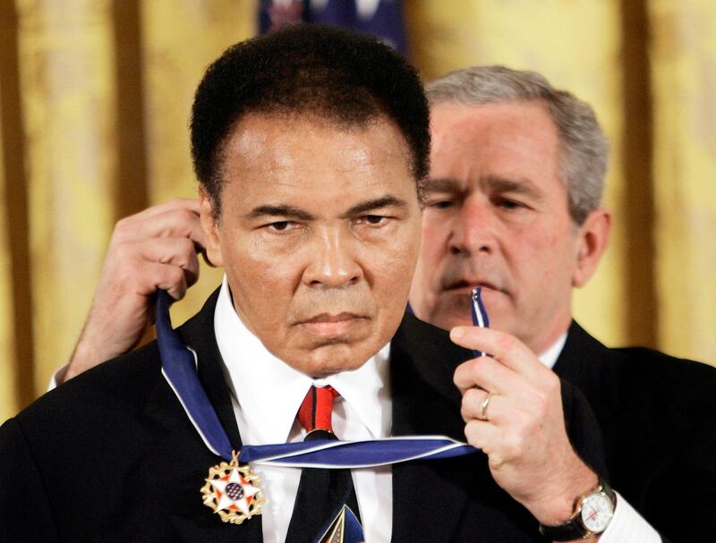 FILE - In this Nov. 2009 file photo, President Bush presents the Presidential Medal of Freedom to boxer Muhammad Ali in the East Room of the White House. President Donald Trump said he is thinking "very seriously" about pardoning Muhammad Ali, even though the Supreme Court vacated the boxing champion's conviction in 1971.  (AP Photo/Evan Vucci)