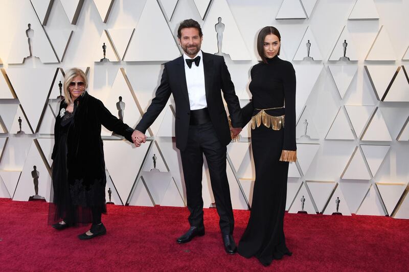 Bradley Cooper, centre, in Tom Ford, Irina Shayk, right, and Gloria Campano at the 91st Academy Awards. AP