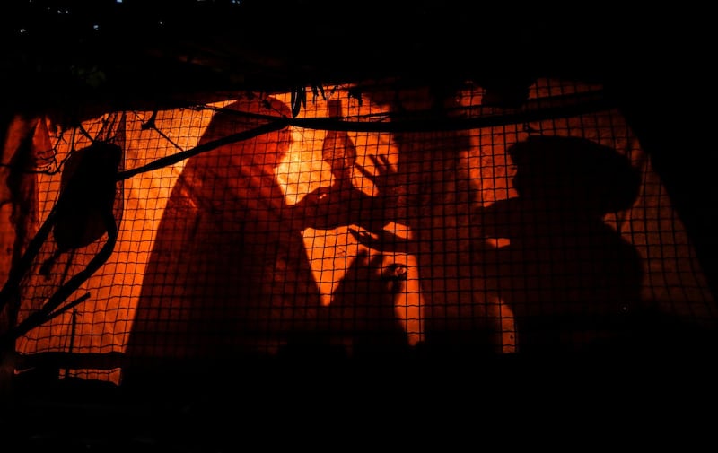 A Palestinian woman uses a gas lamp during a power cut in an impoverished area of the Khan Younis refugee camp, southern Gaza Strip. Mahmud Hams/AFP