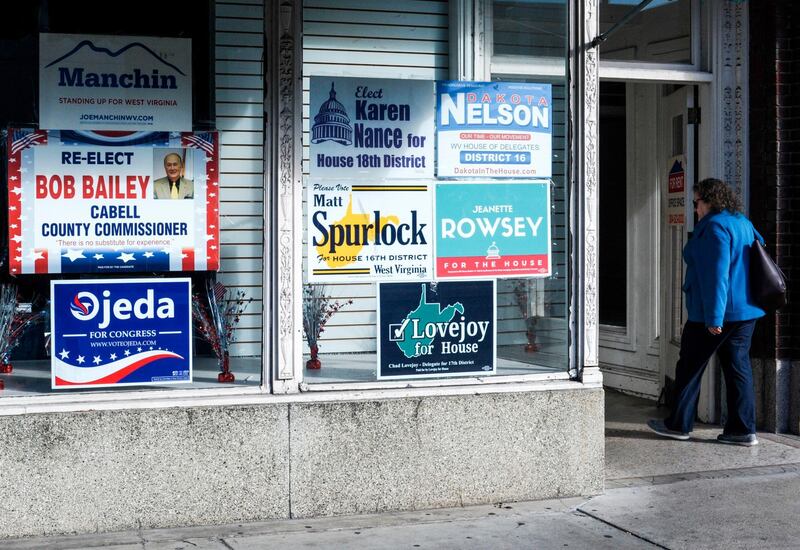 A woman walks past election posters, one of them supporting Richard Ojeda, candidate for a US House seat in West Virginia,  in Huntington, West Virginia, October 19, 2018.
Impoverished Appalachia is a culturally conservative bastion on edge, ground zero in an opioid abuse crisis that has devastated families, and where wages are stagnant, health care costs are rising and the coal industry is gasping for air. Two weeks before midterm elections that will determine which party controls Congress, tough-talking Ojeda is urging voters in West Virginia's third district to swallow a dose of the economic populism he preaches.



 / AFP PHOTO / Michael Mathes / AFP / MICHAEL MATHES
