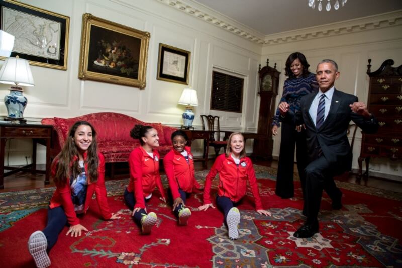 Mr Obama attempts his best split with the 2016 US Olympic Women's Gymnastics Team. Photo: The National Archives