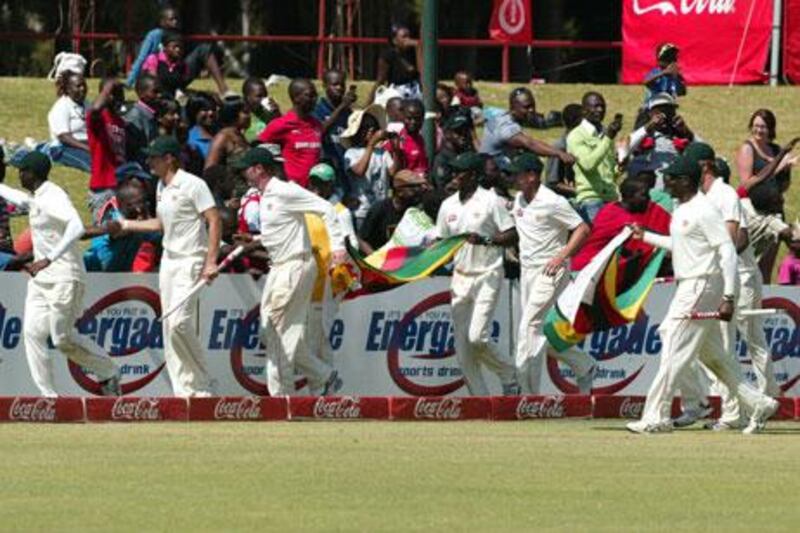 Zimbabwe players carry flags as they take a lap of honour after winning the Harare Test match against Bangladesh on Monday.