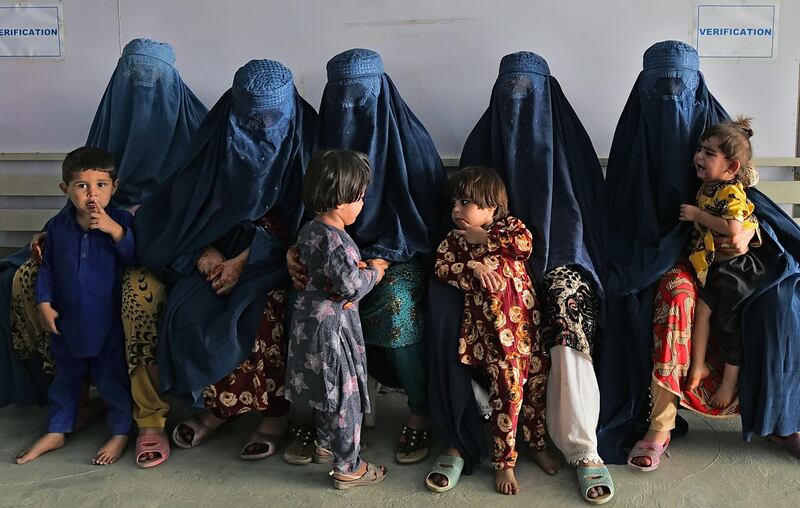 Afghan women wait at the Azakhel Voluntary Repatriation Centre in Nowshera. AFP