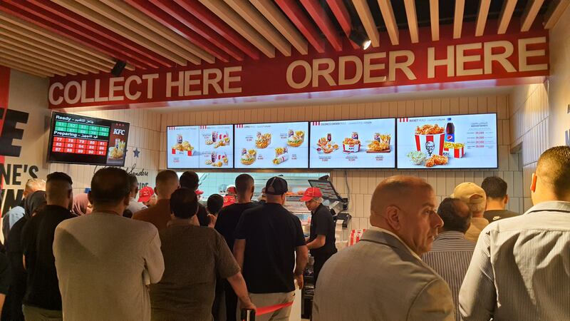 Iraqi customers line up to place their orders inside a KFC restaurant in Baghdad