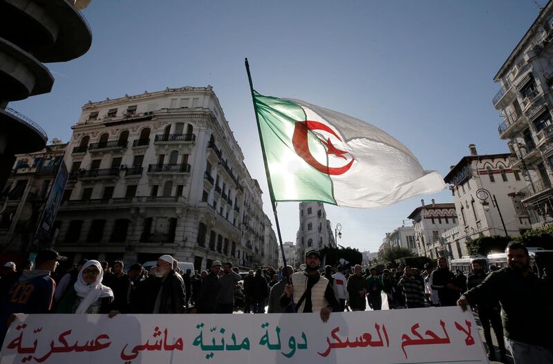Algerian demonstrators take to the streets in to protest against the government and the upcoming presidential elections, inAlgiers, Algeria, Friday, Nov.29, 2019. Thousands of protesters took to the streets of the capital after Friday prayers. Banner reads, "for a democracy, not for a military regime". (AP Photo/Toufik Doudou)