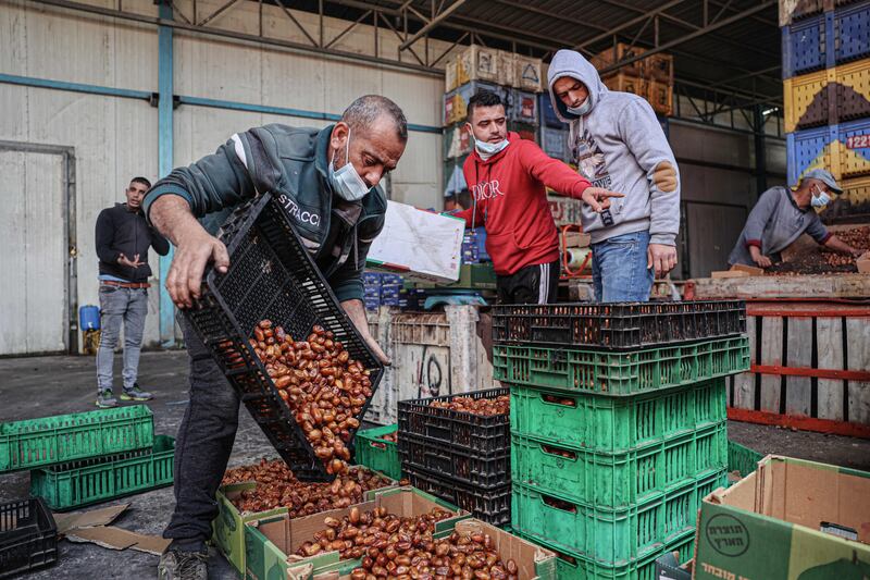 Palestinian workers sort and pack dates at a factory in preparation for the holy month in Khan Yunis in the southern Gaza Strip. AFP