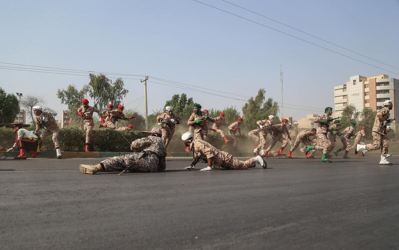 Iranian soldiers, women, and children lay down and run during the attack. EPA