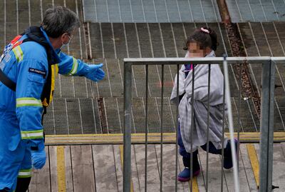 A girl who was among a group of migrants who crossed the English Channel is helped by a British coastguard officer. PA