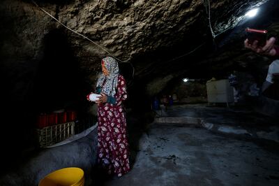 A Palestinian woman arranges her belongings in the cave where she lives, as Israel's Supreme Court rejected a petition against the eviction of more than 1,000 Bedouin from rural Masafer Yatta, south of Hebron, in the occupied West Bank. Reuters