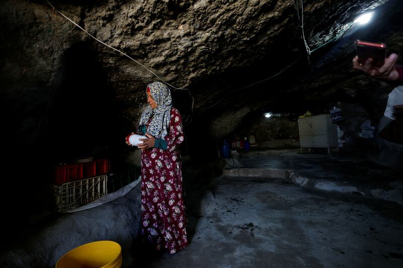 A Palestinian woman arranges her belongings in the cave where she lives, as Israel's Supreme Court rejects a petition against the eviction of more than 1,000 Palestinian inhabitants of a rural part, in Masafer Yatta, South of Hebron, in the Israeli-occupied West Bank, May 7, 2022.  Picture taken May 7,2022.  REUTERS / Mussa Qawasma