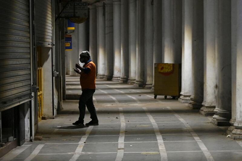 A food delivery worker stands inside a deserted shopping arcade. Delhi announced on Sunday that its lockdown would be extended by another week until May 24, reports said. AFP