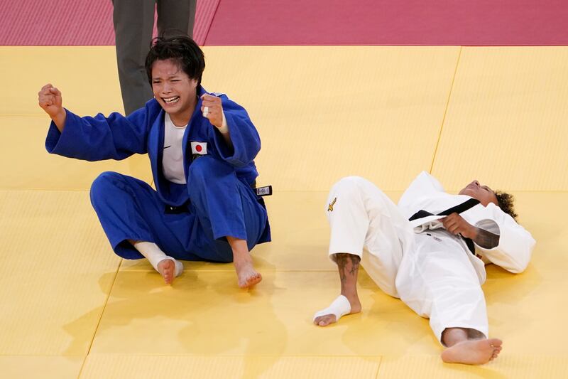 Japan's Uta Abe, of Japan, left, celebrates after defeating Amandine Buchard, of France in the women's -52kg gold medal judo match.