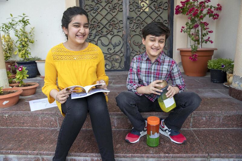 DUBAI UNITED ARAB EMIRATES. 25 NOVEMBER 2020. Safa Kidwai with the book she has published on Amazo and her brother younger Abdullah with his recycled glass jars. (Photo: Antonie Robertson/The National) Journalist: Deepthi Nair Section: National.
