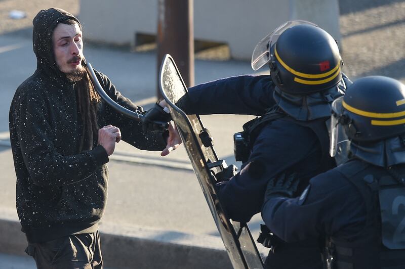 A French police officer hits a protester with a baton during protests over pension reforms in Nantes. AFP