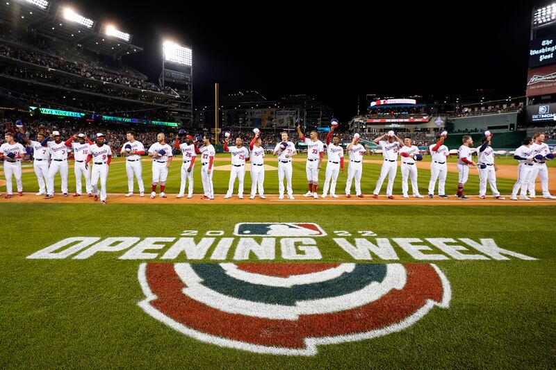 Members of the Washington Nationals wave as they stand on the first base line during pregame festivities in the opening day baseball game against the New York Mets at Nationals Park in Washington. AP