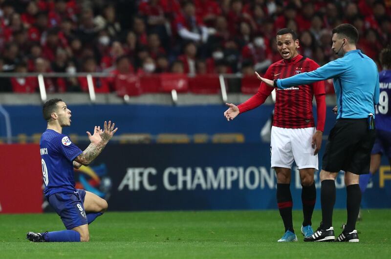 Al Hilal's Abdullah Otayf (L) reacts as Urawa's Ewerton (2nd R) speaks to the referee. AFP
