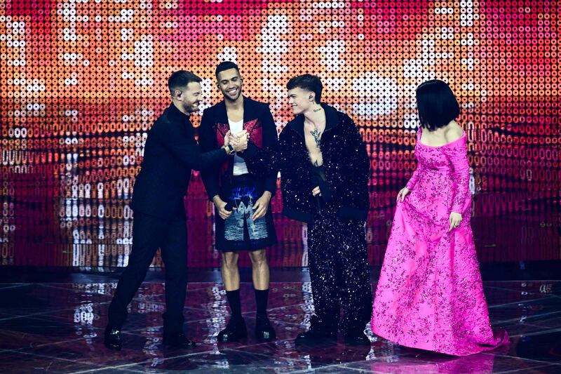 Italian television presenter Alessandro Cattelan, left, taps hands with her compatriot, singer Blanco, as Italian singers Mahmood and Laura Pausini look on during the first semi-final. AFP