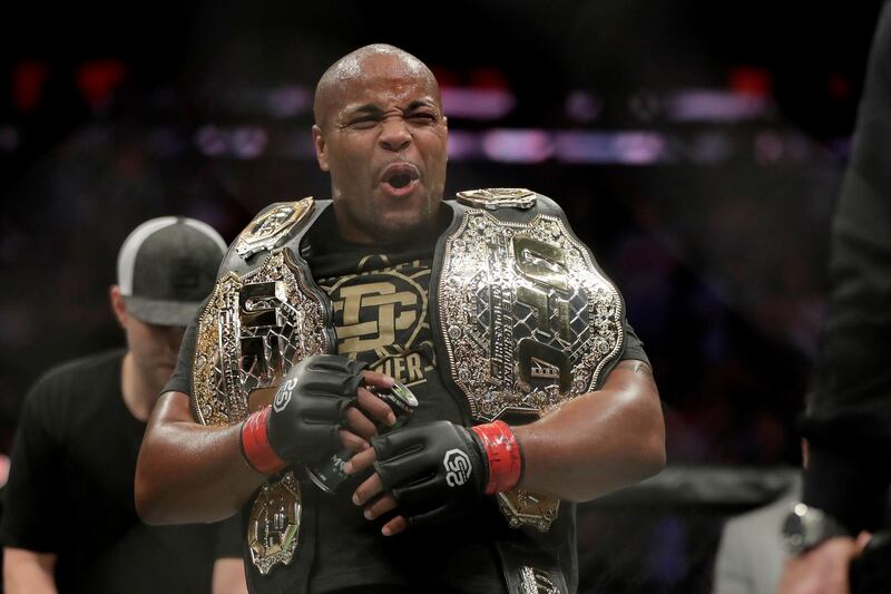 Daniel Cormier holds his belts after defeating Derrick Lewis by submission during the second round of a heavyweight mixed martial arts bout at UFC 230, early Sunday, Nov. 4, 2018, at Madison Square Garden in New York. (AP Photo/Julio Cortez)