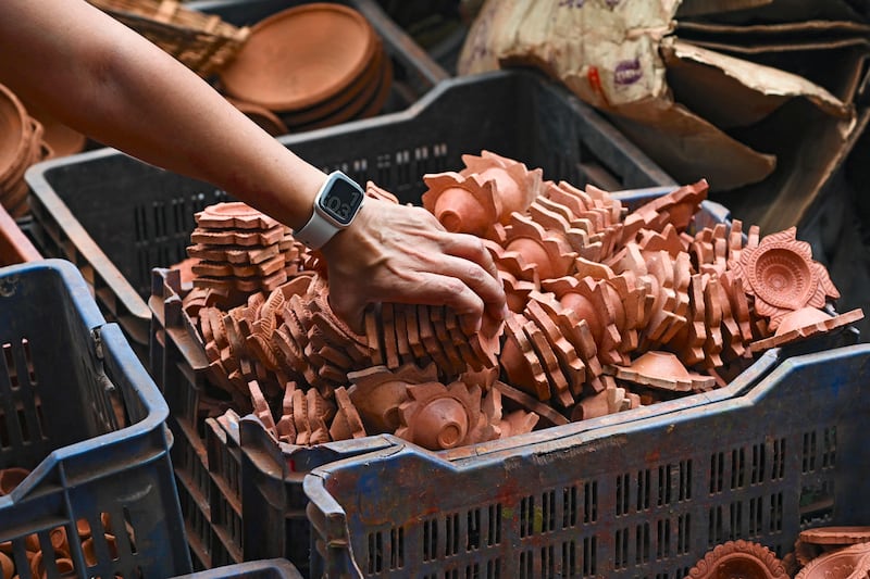 A customer buys earthen lamps at the Kumbharwada potters' colony of Dharavi slums in Mumbai. AFP