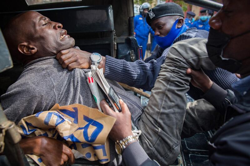 A demonstrator is pushed into the back of a police vehicle during a May Day protest demanding better living conditions during the Covid-19 pandemic, in Nairobi, Kenya. AFP