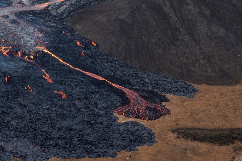 Walkers skirt lava flows from the Fagradalsfjall volcano in Reykjanes Peninsula, Iceland. The volcano, about 40 kilometres west of the capital Reykjevik, started to erupt on Friday after 50,000 small earthquakes were recorded. It last erupted 800 years ago. Reuters