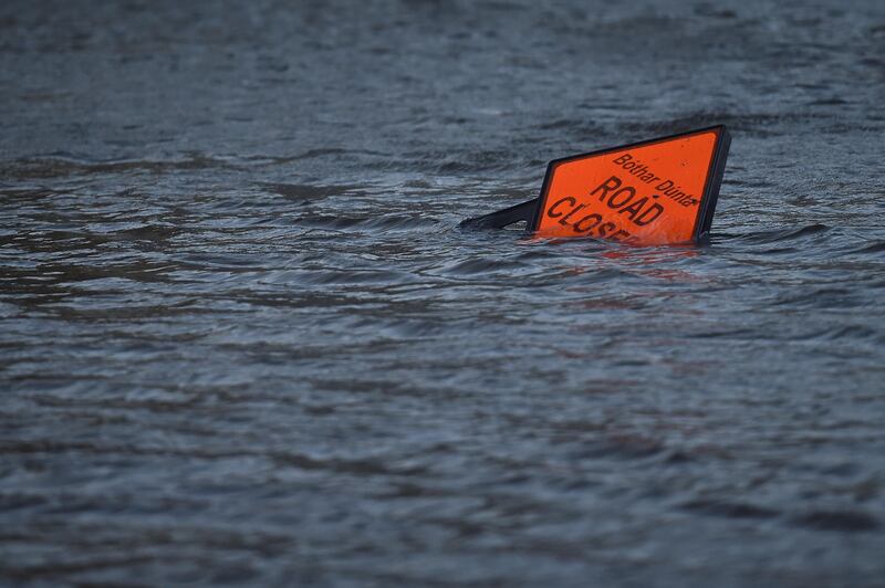 A 'road closed' sign is seen submerged in floodwater during Storm Ophelia in Galway, Ireland. Clodagh Kilcoyne / Reuters
