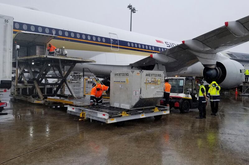 A shipment containing coronavirus vaccines is unloaded from a plane upon arrival in Auckland as New Zealand receives its first batch. New Zealand Ministry of Health via AP