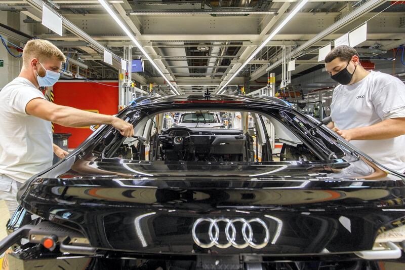 Workers wearing protective face masks secure rear window frame fittings to an Audi e-Tron electric automobile on the assembly line at the Audi AG factory, operated by Volkswagen AG, in Brussels, Belgium, on Thursday, June 4, 2020. By taking on an additional $72 billion in new debt to get through the coronavirus pandemic,Â automakersÂ and theirÂ suppliersÂ have entered a profit desert where returns will be decimated by slumping sales and costly investments. Photographer: Olivier Matthys/Bloomberg via Getty Images