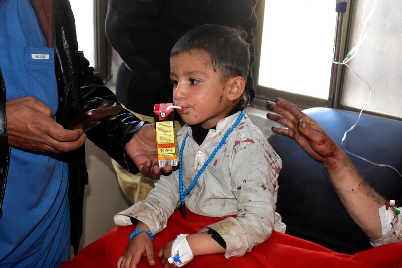 An injured boy takes a drink after receiving hospital treatment. AP