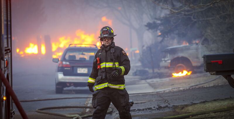 A firefighter walks back to his fire engine as a fire sweeps through the Centennial Heights neighbourhood of Louisville.  AFP