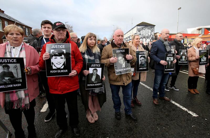 Relatives and supporters of the victims of the 1972 Bloody Sunday killings hold images of those who died as they march from the Bogside area of Derry, Northern Ireland on March 14, 2019, towards the City Hotel to hear an announcement due to be made by prosecutors. Northern Ireland's Public Prosecution Service will announce Thursday if the British soldiers involved in the January 30, 1792 "Bloody Sunday" killings of thirteen civil rights demonstrators in Derry (Londonderry), will face court action. / AFP / Paul FAITH
