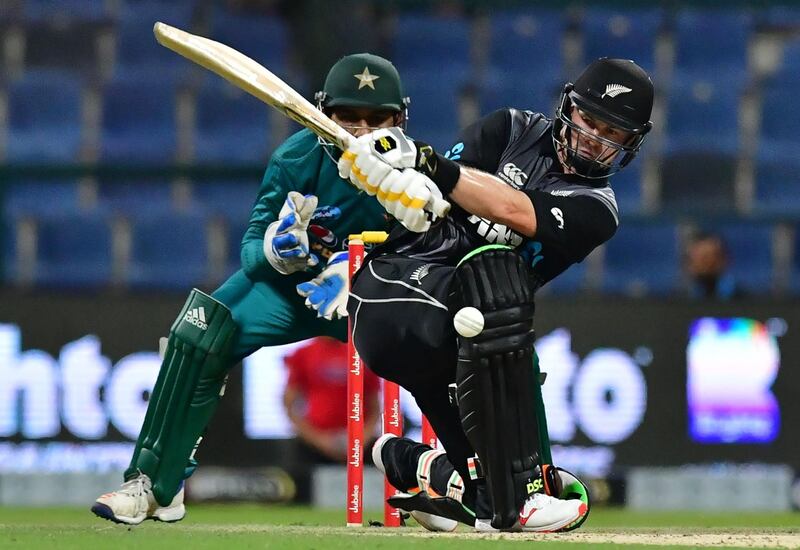 New Zealand cricketer Colin Munro plays a shot as Pakistan's wicketkeeper Sarfraz Ahmed looks on during the first T20 cricket match between Pakistan and New Zealand at The Abu Dhabi Cricket Stadium in Abu Dhabi on October 31, 2018.  / AFP / GIUSEPPE CACACE
