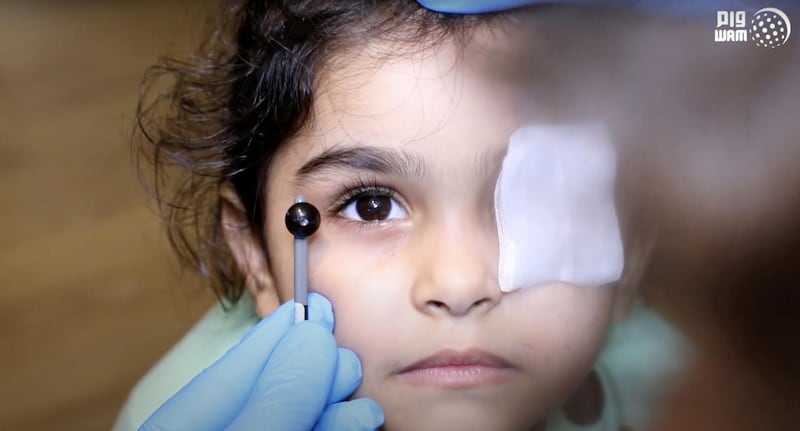 Sama, 5, has her eye colour matched by a doctor. Wam