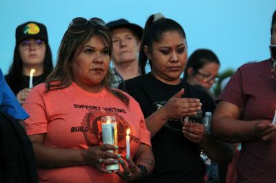 Community members hold candles during a vigil after an 18-year-old gunman killed three people in Farmington, New Mexico. AP